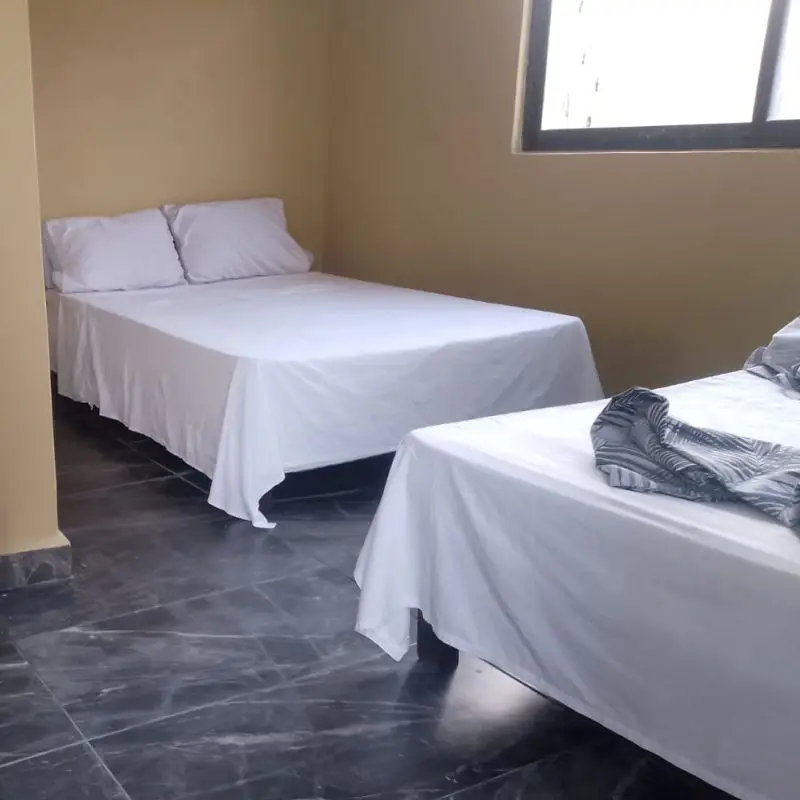 Habitación climatizada con dos camas matrimoniales en Casa Milagros Chachalacas.