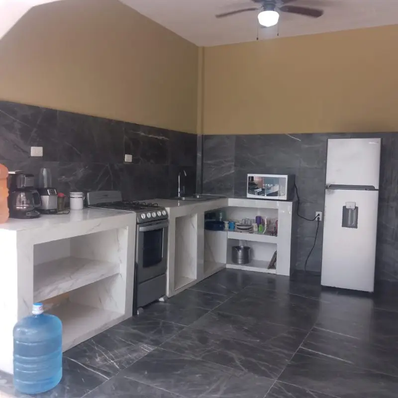 Cocina equipada con refrigerador, estufa y electrodomésticos en Casa Milagros Chachalacas.