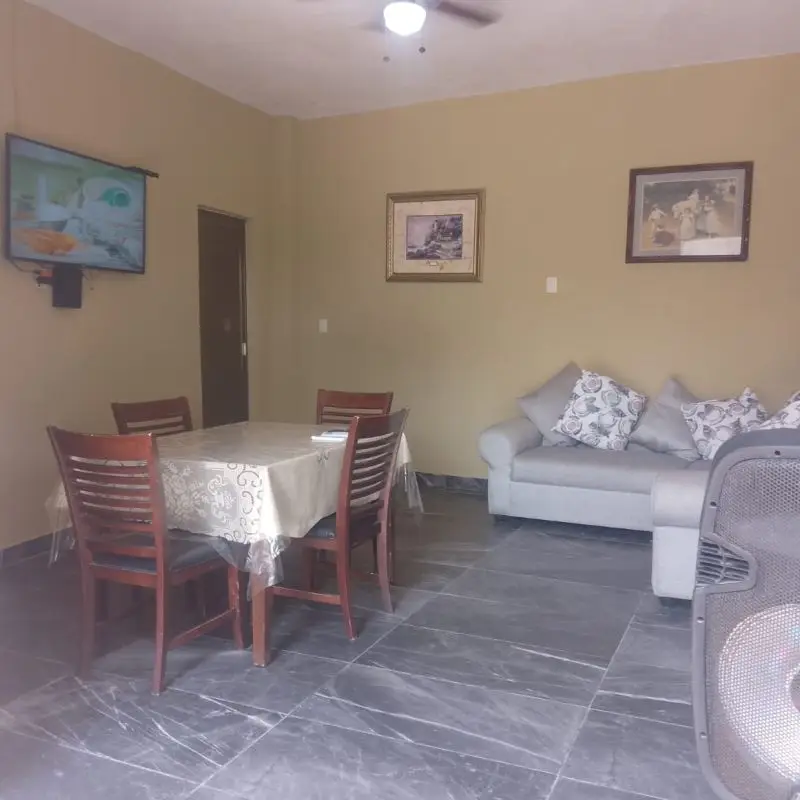 Sala de estar y comedor interior en Casa Milagros Chachalacas con sillón y pantalla de televisión