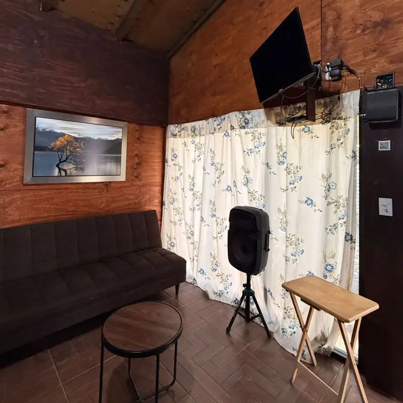 Sala de estar rústica en Cabaña Don Moy Chachalacas con sofá cama y pantalla de TV.