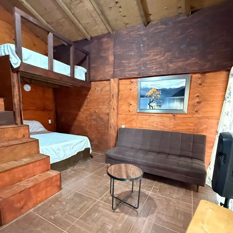 Distribución de camas y sofá cama en el interior rústico de Cabaña Don Moy Chachalacas.