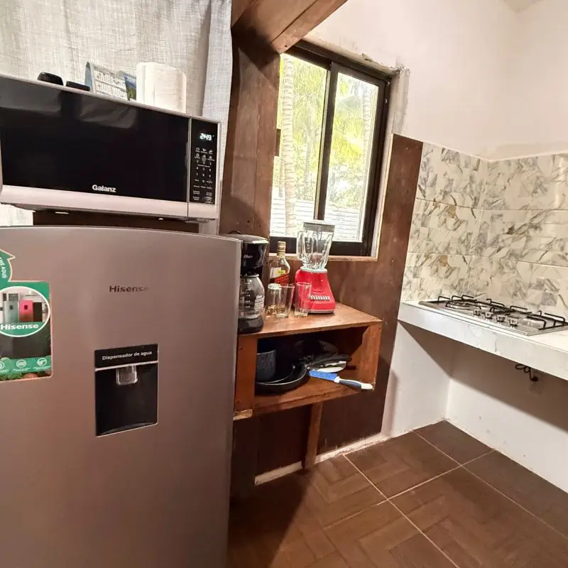 Cocina completa equipada con refrigerador, microondas y estufa en Cabaña Don Moy Chachalacas.